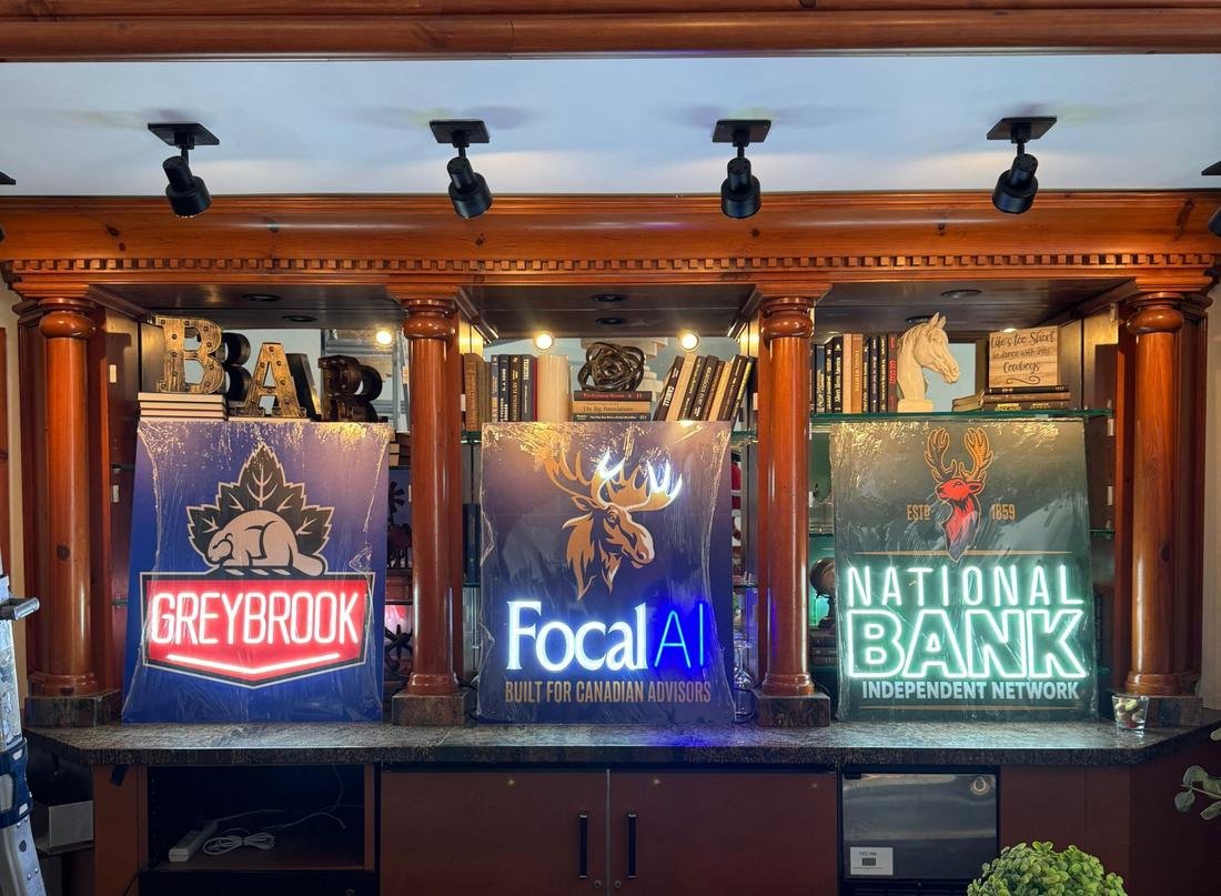 Three backlit logo signs with neon style lettering on a bar counter, in red, white and green